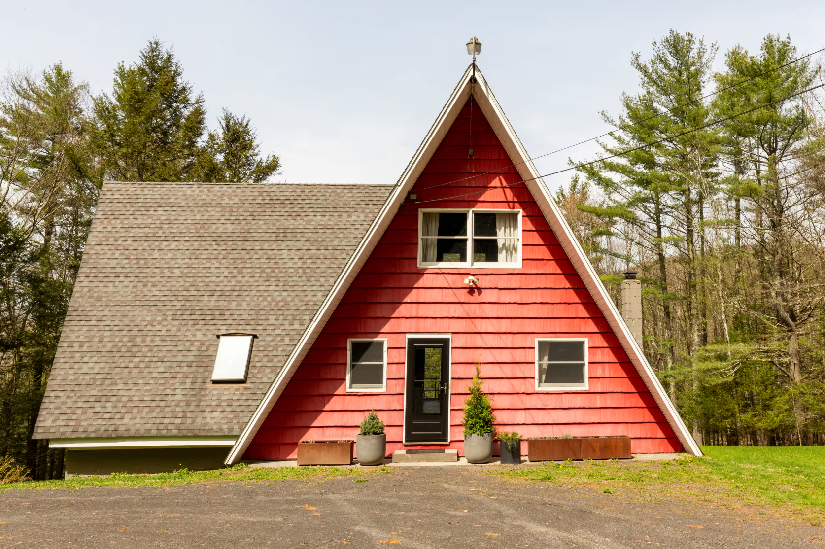 The red A-frame cabin exterior surrounded by trees
